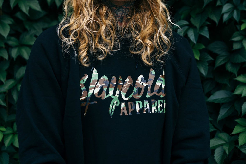 Male tattooed Model wearing the new Stay Cold Apparel Variation of the Essential Logo Hoodie in Camouflage Woodland