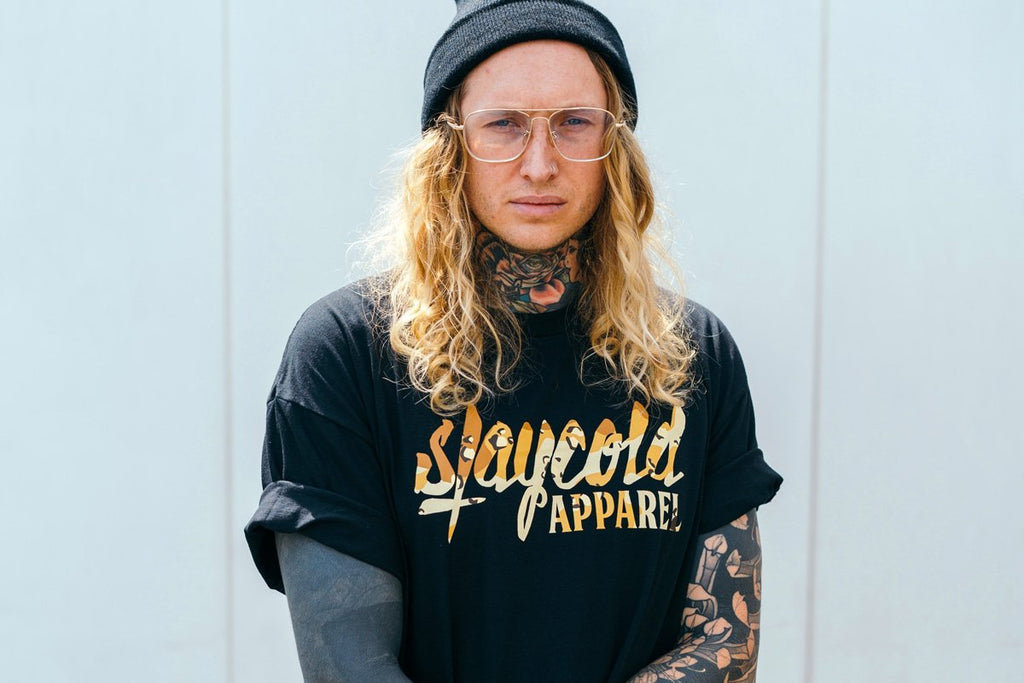 Male Tattooed Model wearing the new Stay Cold Apparel Variation of the Essential Logo Tee in Camouflage Sand
