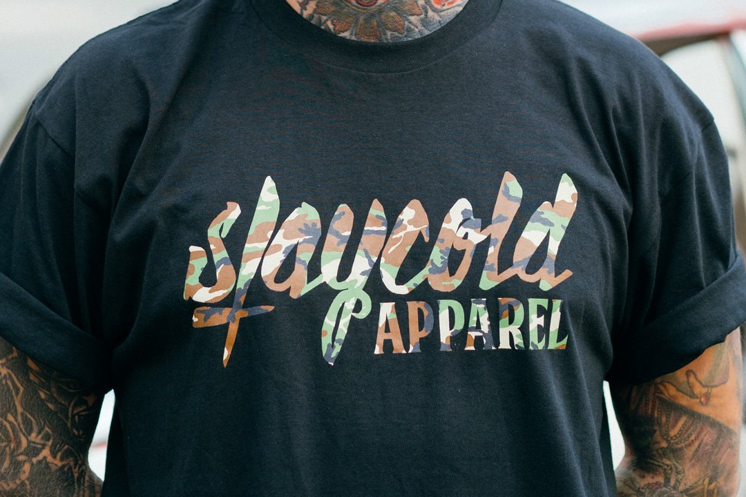 Tattooed Model in the new Stay Cold Apparel Variation of the Essential Logo Tee now in Camouflage Woodland