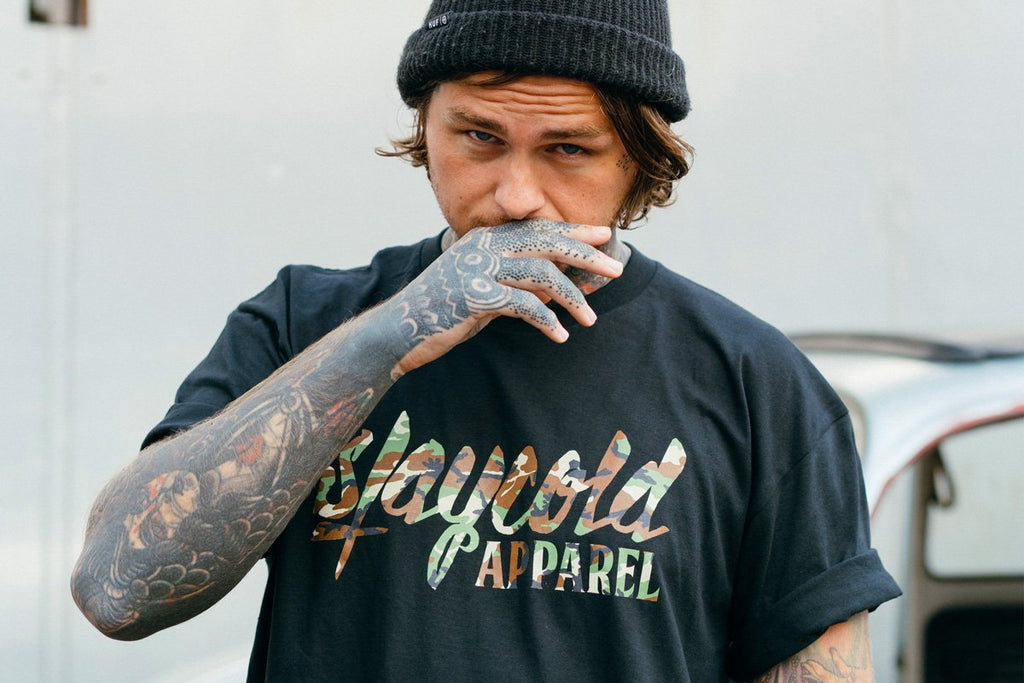 Tattooed Model in the new Stay Cold Apparel Variation of the Essential Logo Tee now in Camouflage Woodland